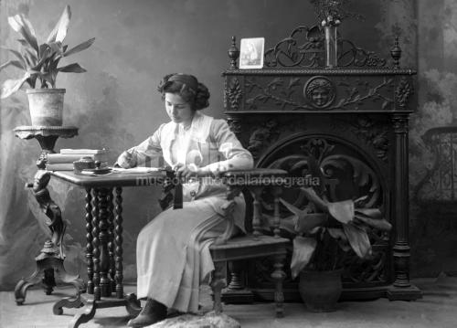 Anonimo, Giovane donna ritratta in atelier, 1904 circa, gelatina bromuro d' argento/ vetro, CC BY-NC-ND