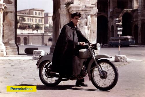 Fattorino telegrafico con divisa invernale completa di mantella impermeabile, in sella ad una Moto Guzzi, nei pressi dell'Arco di Costantino a Roma (anni Cinquanta - Sessanta), CC BY-NC-ND