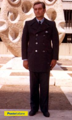 Impiegato posa davanti scultura dell’artista Antonino Virduzzo, nel piazzale del Ministero delle Poste e Telecomunicazioni dell'Eur, indossando la nuova divisa (1980), CC BY-NC-ND