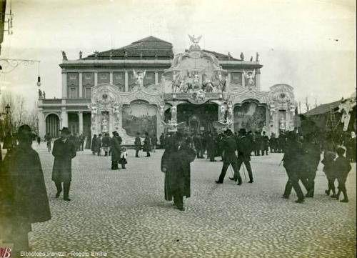 Sevardi , Roberto, Giostra tedesca davanti al Teatro M.[Municipale], 1900 circa, fotografia bianco e nero : gelatina bromuro d'argento su carta baritata ; 120x160 mm., CC BY-NC-ND