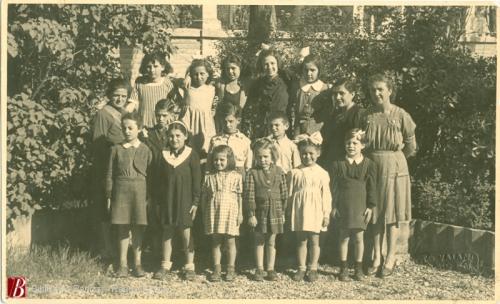 Foto Vaiani, Gruppo di bambini dell'asilo insieme alle maestre,, 1945 circa, 1 fotografia bianco e nero : gelatina bromuro d'argento su carta baritata ; 84x137 mm., CC BY-NC-ND