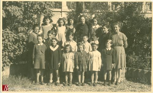 Foto Vaiani, Gruppo di bambini dell'asilo insieme alle maestre,, 1945 circa, 1 fotografia bianco e nero : gelatina bromuro d'argento su carta baritata ; 84x137 mm., CC BY-NC-ND