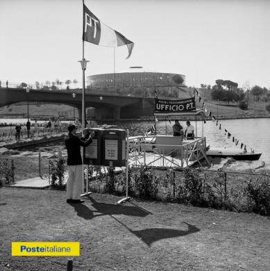 1960, Roma. Durante le XVII Olimpiadi un motoscafo attrezzato a ufficio postale fa servizio tra le opposte rive del laghetto dell’Eur, zona molto frequentata da turisti e spettatori trovandosi tra il Palazzetto dello Sport e il Velodromo, CC BY-NC-ND