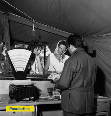 1960, Roma. Interno dell’ufficio postale da campo allestito nel campeggio internazionale di Monte Antenne per servire i numerosi turisti arrivati a Roma in occasione delle XVII Olimpiadi, CC BY-NC-ND