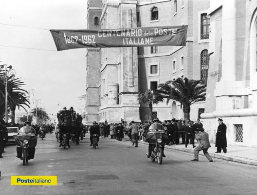 1962, Taranto. Una delle antiche diligenze postali, ricostruite in occasione delle celebrazioni del primo centenario delle Poste Italiane, passa per le strade della città alla volta di Roma, scortata dalla polizia urbana, CC BY-NC-ND