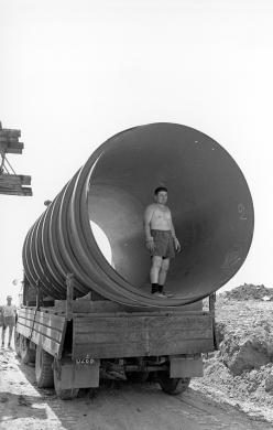 Enrico Pasquali, Impianto del Palantone sul Po. Salvatonica, Bondeno (FE). Operaio in uno dei tubi di aspirazione., 7/1967, gelatina bromuro d'argento/carta, CC BY-NC-ND