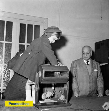 5 gennaio 1957, Roma. Lotteria della Befana organizzata dal Dopolavoro per i dipendenti delle Poste, con la partecipazione del Sottosegretario delle Poste Francesco Vigo (nella foto, in completo gessato), CC BY-NC-ND