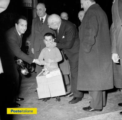 1960, Roma. Si festeggia la Befana postelegrafonica al Circo Orfei, con regali e cotillon. Nella foto, il figlio di un dipendente delle Poste insieme al Ministro Giuseppe Spataro, CC BY-NC-ND