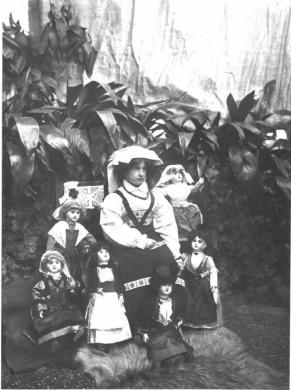 Michelini, Giuseppe, Virginia Majani in costume ciociaro contornata da bambole, gelatina bromuro d'argento su pellicola, CC BY-SA