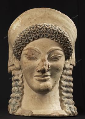 Archivio fotografico Museo archeologico reg. Paolo Orsi SR - Gallitto G., Antefissa del Fusco- Necropoli del Fusco (SR)-535-500 a.C.- Fanciulla con diadema, che rappresenta una menade o una ninfa. Le menadi sono seguaci mitologiche di Dioniso. La chioma in ciocche ondulate, gli zigomi sporgenti, la bocca carnosa e il taglio obliquo degli occhi sono tipici dell'arte arcaica diffusa in Sicilia in questo periodo storico. Un'altra testa identica venne ritrovata trent'anni dopo nello stesso luogo. Si ipotizza che le teste fossero antefisse a decorazione delle testate delle travi del tetto di un piccolo edificio sacro., fotografia Still life digitale, CC BY-NC-ND