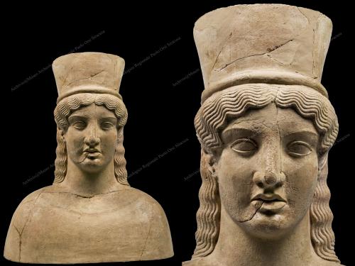 Archivio fotografico Museo archeologico reg. Paolo Orsi SR - Gallitto G., Busto da Grammichele- 480 a.C.  - Trovato con altre maschere e busti fittili nelle grotte sacre e nei depositi votivi, questo è considerato un capolavoro dello stile artistico "severo", in un periodo tra l'arte arcaica e quella classica. Nella parte posteriore del busto, si trova un'iscrizione graffita che recita "fiorisci". Una dedica a una divinità femminile, Demetra, dea delle messi e della fecondità umana; invocata anche durante i riti di passaggio dalla condizione verginale alla maturazione sessuale., fotografia still life digitale, CC BY-NC-ND