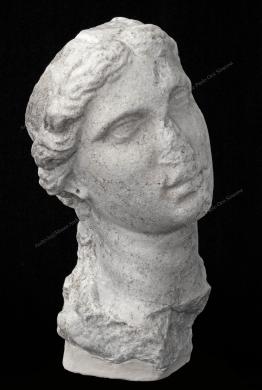 Archivio fotografico Museo archeologico reg. Paolo Orsi SR - Gallitto G., Testa femminile - da Siracusa - fine III, inizi II sec. a.C. La testa, più piccola del vero, ha un'espressione patetica per la leggera inclinazione e per lo sguardo languido rivolto verso l'alto. Il volto ovale allungato è incorniciato dai capelli acconciati semplicemente, con ciocche ondulate ai lati del collo e sulle spalle. L'opera mostra una notevole espressività, tipica di alcuni ritratti dell'Egitto tolemaico., fotografia still life digitale, CC BY-NC-ND