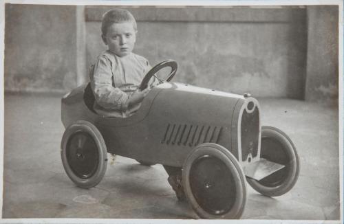 Fotografo non identificato, Dino Manetti, allievo della scuola dell'infanzia del Pio Istituto dei Sordi, su una automobile giocattolo, 1934, gelatina ai sali d'argento/carta, CC BY-NC-ND