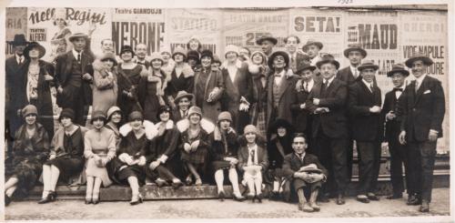 Anonimo, Compagnia di rivista "La Nuovissima", gestita dal commendatore Fiandra, con l'attrice Isa Bluette, gli artisti, gli autori Rip, Bel-Ami e Albertazzi, le ballerine e i tecnici, tutti radunati in piazzo Solferino a Torino, dinanzi ad uno steccato posto presso la Fontana Angelica. C.S.P., FONDO “ANGELO ALESSIO”, FASC. 33, 1925, gelatina ai sali d'argento, CC BY-SA