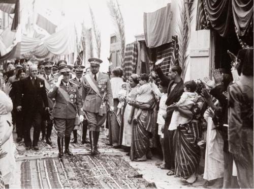 Istituto Nazionale Luce, Visita diplomatica in Tripolitania del Re e Imperatore Vittorio Emanuele III. Il re accompagnato da Italo Balbo visita il Bazar di Tripoli 1938, maggio 20 – giugno 3 C.S.P., FONDO “ASINARI ROSSILLON DI BERNEZZO”, FASC. 20, 05/1938, gelatina ai sali d'argento, CC BY-SA
