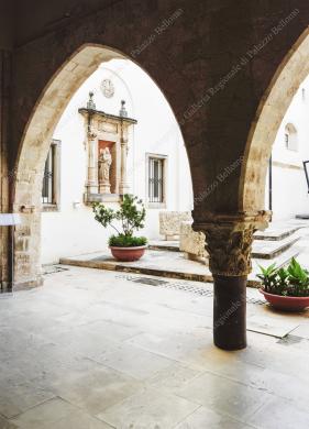Archivio fotografico Galleria reg. di Palazzo Bellomo, Immagine digitale a colori, ripresa dal portico dell’ingresso del palazzo, con veduta di uno scorcio del cortile occidentale. Anno 2024. Autore: G. Gallitto., Ripresa in esterni, CC BY-NC-ND