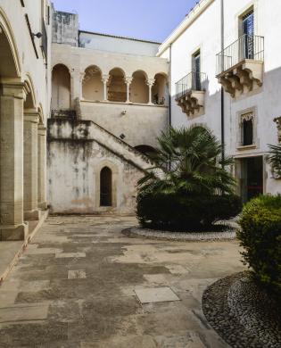 Archivio fotografico Galleria reg. di Palazzo Bellomo, Immagine digitale a colori, anno 2024, ripresa dal Cortile degli Stemmi con veduta della scala e della loggia al piano superiore, in stile catalano. Autore: G. Gallitto., Ripresa in esterni, CC BY-NC-ND