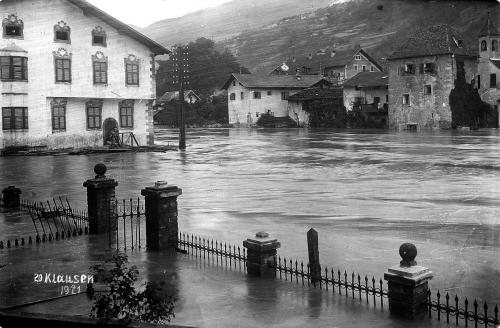 Alluvione del 1921: ex casa Bärburg sulla sponda sinistra dell'Isarco, sulla sponda destra la odierna canonica con torre del sagrestano. Chiusa, 1921 ARCHIVIO FOTOGRAFICO ERICH PLANINSCHEK, n. 210, CC BY-NC-SA