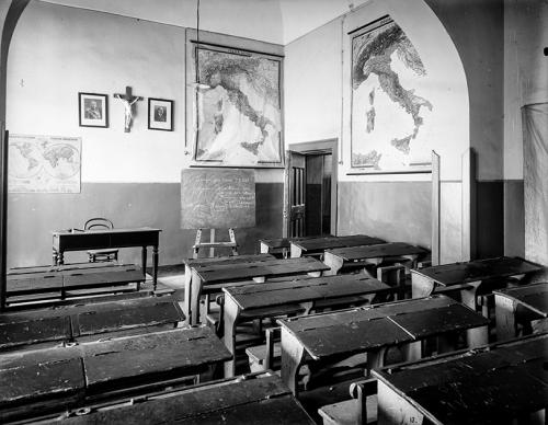 Domenico Losacco De Gioia, Regio Istituto  Alfonso Casanova. Aula  di Storia e Geografia. Scritte alla lavagna: “Assegno per lunedì 27-2-28 Geografia - Africa italiana - Riassunto orale delle letture : Il commercio dello sparto a Tripoli - Asmara - Diritti e doveri - Il dovere e la libertà del lavoro”, 1928, lastra alla gelatina al bromuro d'argento, CC BY-SA