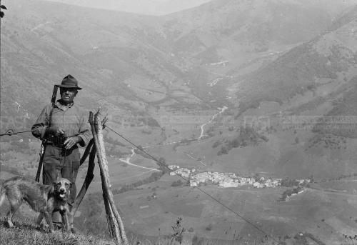Gnocato, Giuseppe, Un cacciatore con il suo cane su un pendio montano; sul fondo il paesino di Miles di Segusino (TV), 1960 ca. - Fondo G. Gnocato -., gelatina al bromuro d'argento/ pellicola, CC BY-SA