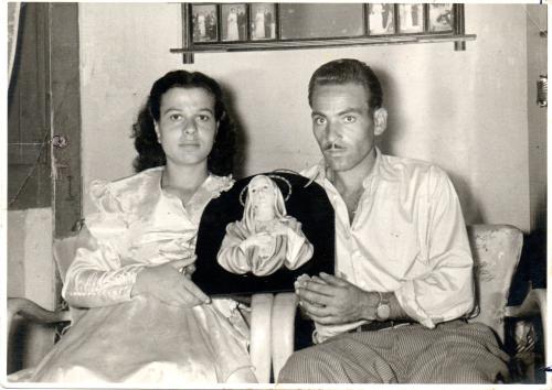 Maltese, Angelo, I coniugi Iannuso nella loro casa in Via degli Orti nei giorni della Lacrimazione, che sorreggono il Quadretto miracoloso, 08/1953, stampa su carta gelatina ai sali d'argento, CC BY-NC-ND