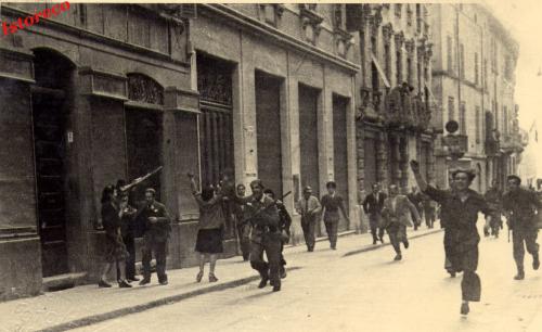 Partigiani attraversano la via Emilia in centro a Reggio Emilia il giorno della liberazione della città, 24/04/1945, CC BY-NC-ND
